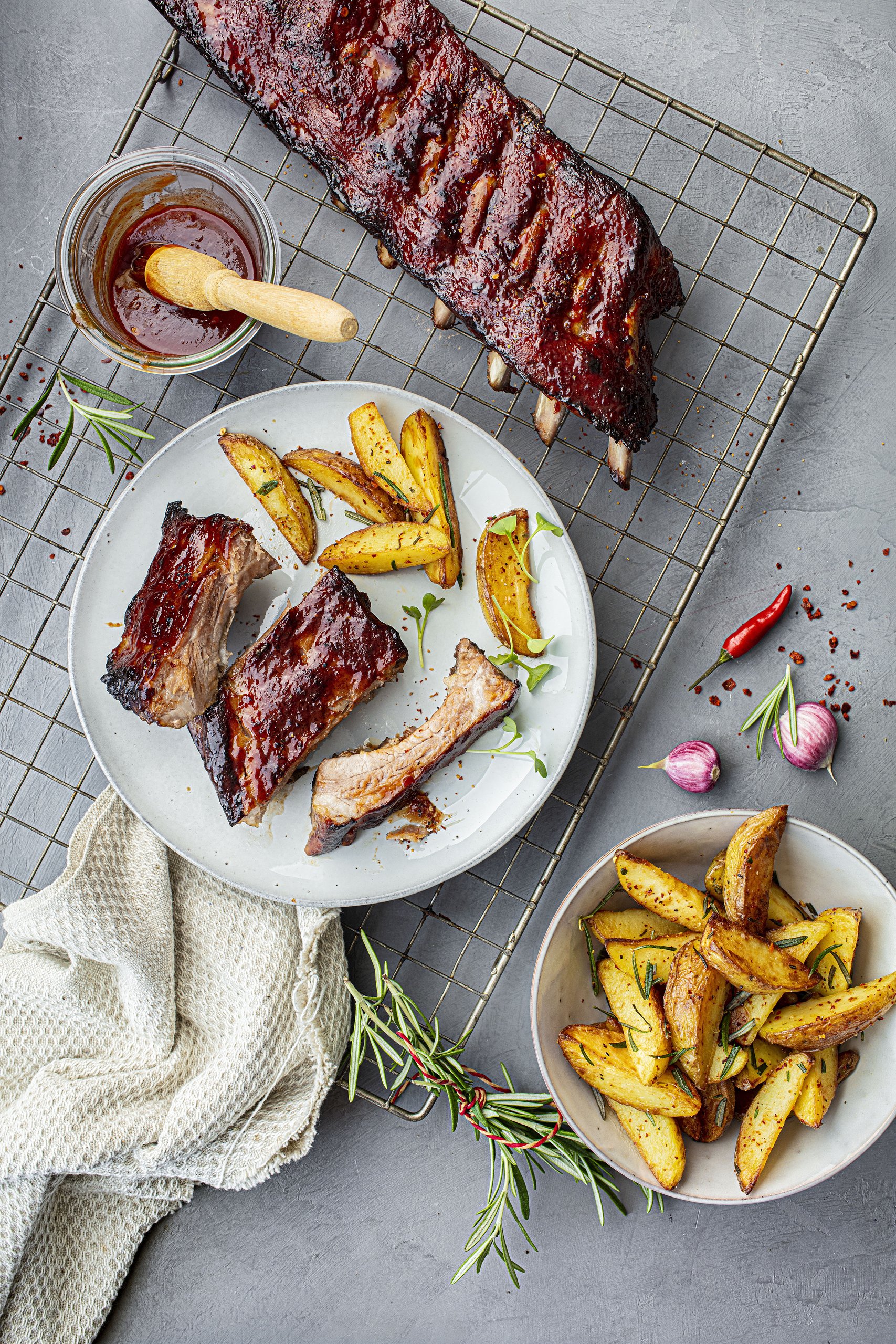 Rippchen mit gewürzten Kartoffelspalten und Rosmarin angerichtet