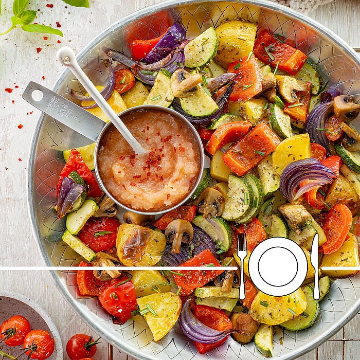 Eine silberne Schüssel, gefüllt mit Ofengemüse und einer kleiner Schüssel mit Dip. Herum Gewürze und Tomaten 