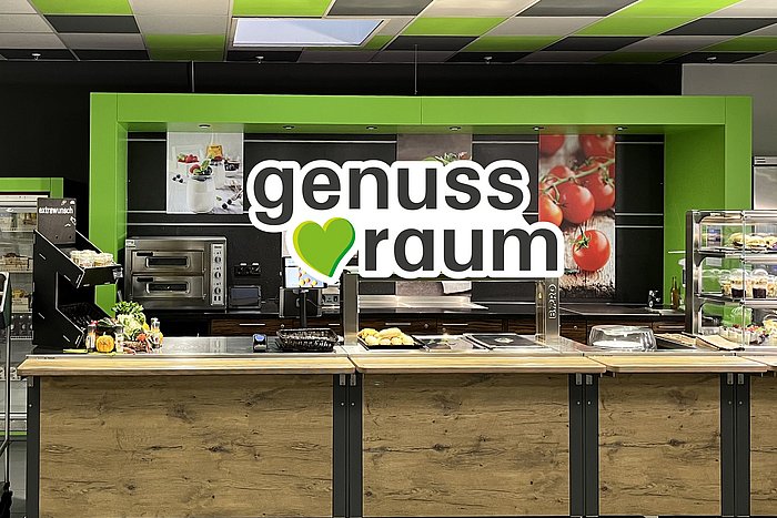 Eine große offene Küche mit dem Logo "genussraum"